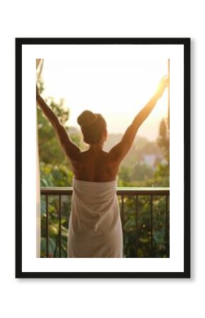 Woman towel morning sunlight balcony view open curtains stretching wellness spa