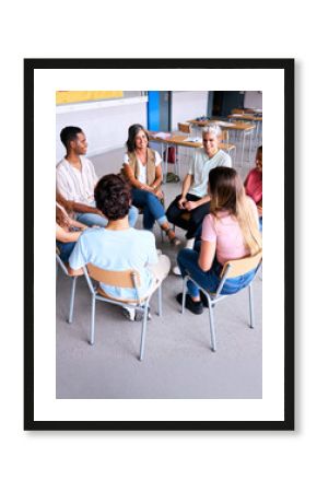 Vertical. A group of students and a teacher sit in a circle during a school group therapy session, promoting communication, trust and mental health support among teenagers.
