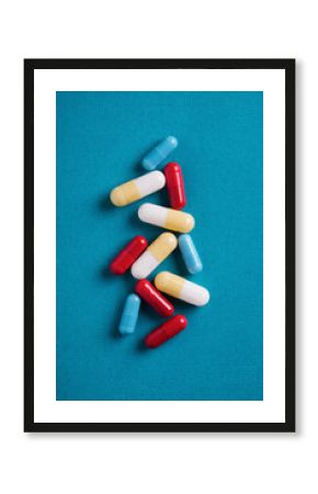 Colorful medicine capsules on blue background symbolize health