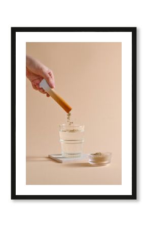 An aesthetic image showing powder being dissolved into a glass