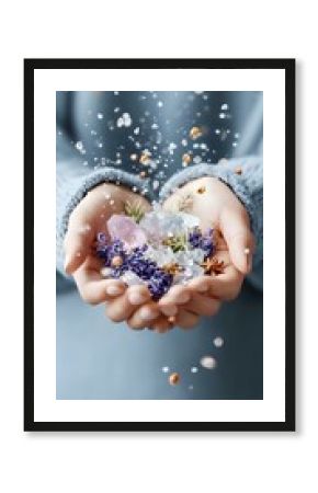 Female hands holding crystals, lavender flowers, and star anise with magical sparkles and bokeh effects against soft blue background, creating mystical atmosphere.