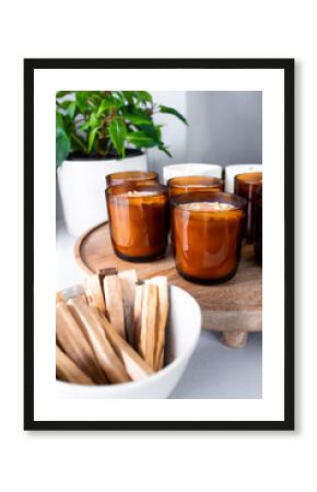 Aromatherapy candles and palo santo on wooden tray for relaxing ambiance