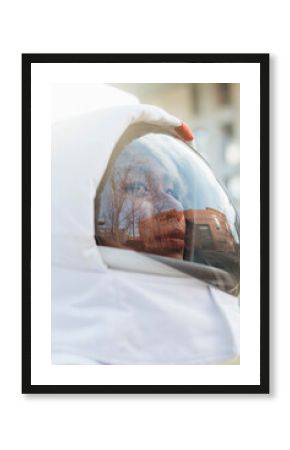 Young female astronaut day dreaming while wearing space helmet