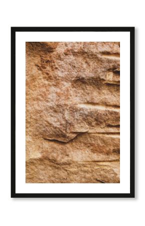 Brown rough sandstone wall with groove carving on surface for abstract background and texture, interior or exterior design. Beautiful patterns, space for work, banner, close up.Vertical.