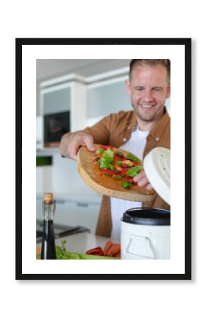Man holding cutting board tipping chopped red peppers, lettuce into cooker in kitchen, copy space