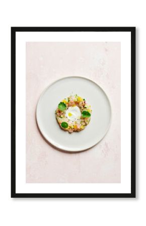 Overhead shot of snapper crudo (raw fish) with coconut, finger lime, cucumber, yuzu, yellow chilli oil and nasturtium leaves, on a pink surface with copy space