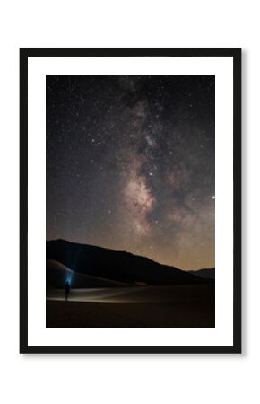 View of serene night sky filled with stars and the milky way over tranquil sand dunes, Death Valley National Park, California, United States.