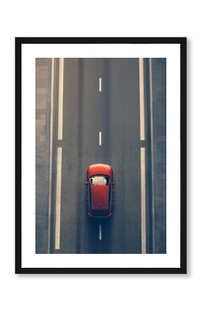 aerial view of modern red car driving on straight asphalt city road with copy space