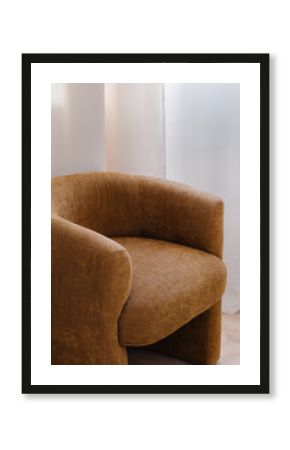 Cozy brown fabric armchair near white curtain in serene space