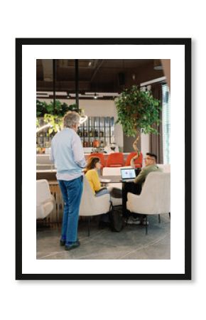 IT company boss checking work of multiracial team in open space office