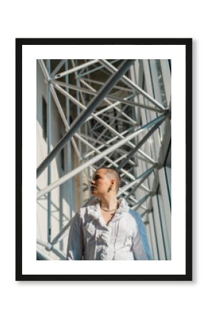 Person in white ruffled shirt standing in modern architectural space
