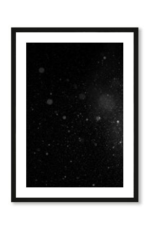A vertical, abstract monochrome image of faint, shimmering particles scattered across a deep, dark expanse