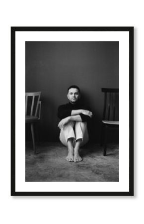 Man between chairs in minimal space