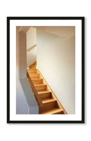 A wooden stair case with two turns in a narrow space in a house.