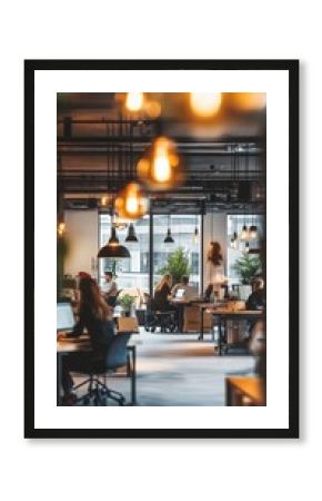 Modern coworking space with warm lighting and industrial decor. Professionals work at desks amid hanging lamps and potted plants, creating a vibrant atmosphere.