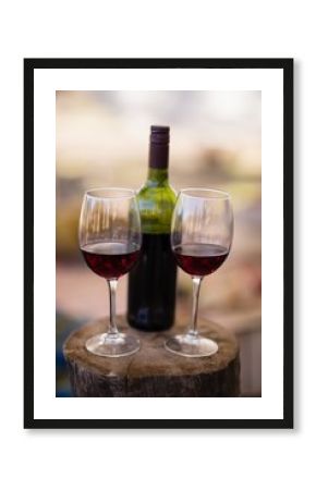 Wine bottle and glass on wooden log