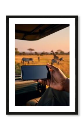 A person in a safari vehicle photographs wildlife with a smartphone.