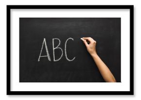 Woman writing abc on black chalkboard