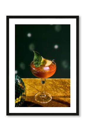 Red cocktail with mint leaf and fruit garnish on glitter table with disco vibe. Concept of nightlife, bar promotion, festive celebration, mixology art, and premium alcohol branding.