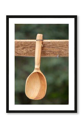A wooden spoon is hanging from a wooden post
