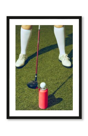 Golfer preparing swing with club and golf ball balanced on pink copy space can. Concept of premium sports branding, beverage lifestyle, advertising mockups, and creative party visuals.
