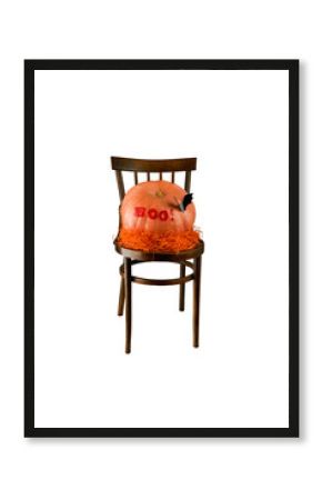 Big pumpkin with the words boo and bat on old retro chair in white with clipping path. Design element for card Halloween party.