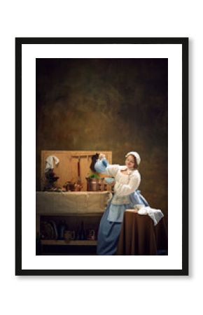 Poster. Young chubby woman in historical dress holds blue pitcher, surrounded by vintage kitchenware and herbs. Concept of bar, pub, Bavarian style, Oktoberfest. Comparisons of eras.