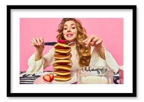 Food pop art. Adorable girl with red hair starting eat giant portion of pancakes with enjoying facial expression over pink background