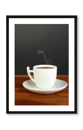 Cup of coffee on wooden table on black background