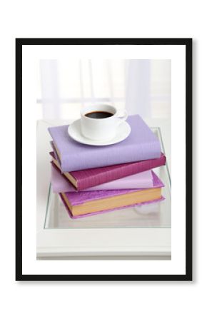 Purple books with cup near sofa