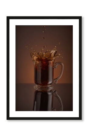 Ice cappuccino splash, refreshing mug of coffee on brown background.