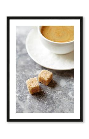 Two brown sugar cubes and a cup of coffee