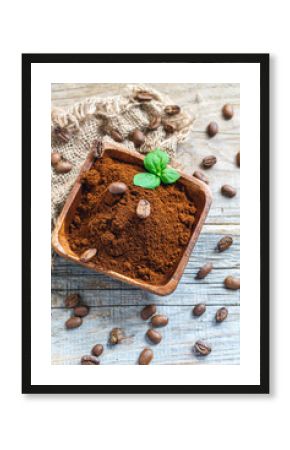 Wooden bowl with ground coffee, mint and coffee beans.