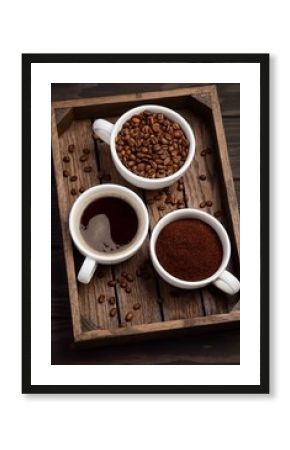 Different types of coffee - ground, grain and beverage on dark wooden background, selective focus, vertical.