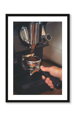 Coffee grinder grinds freshly coffee beans in a portafilter