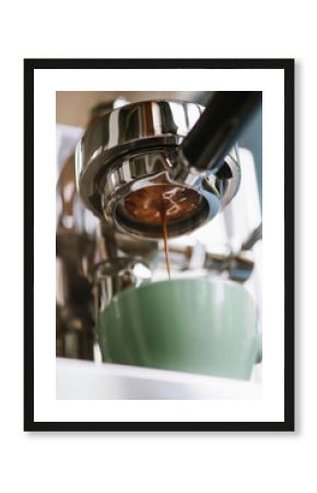 The process of making coffee step by step. Delicious freshly ground morning espresso coffee with a beautiful crema pouring through the bottomless (naked) portafilter into a ceramic green cup