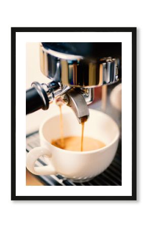 Coffee making, hot coffee flowing into a cup from espresso machine