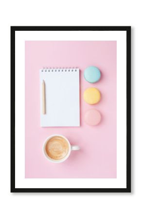 Empty notepad, coffee and colorful macaron on pink pastel desk top view. Cozy morning breakfast. Fashion flat lay. Sweet macaroons.