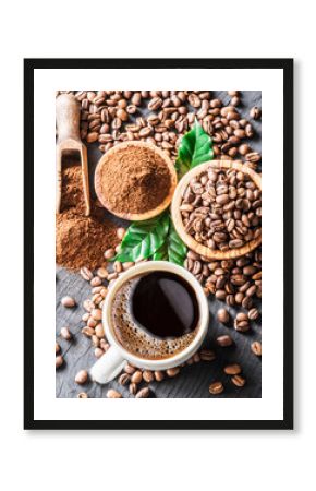 Roasted coffee beans, ground coffee and cup of coffee on wooden table.