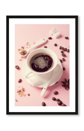 White cup of coffee with coffee beans, candy sugar and spices on pink background. Retro style toned.