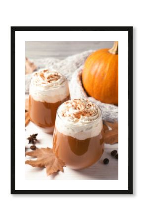 Glasses with tasty pumpkin spice latte on wooden table