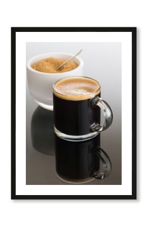 Black coffee and froth in glass mug with sugar