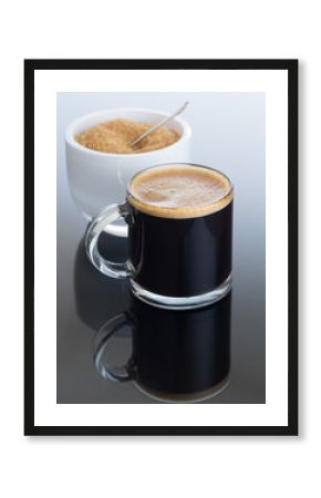 Black coffee and froth in glass mug with sugar