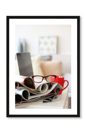 Magazines and laptop on table in living room, close up