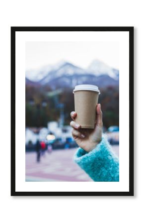 Girl's hand holding a cup of warming beverage with Mountain View