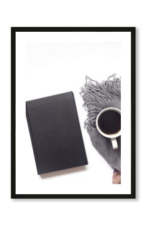 notebook or book with black coffee on white desk background with gray scarf. flat lay. top view