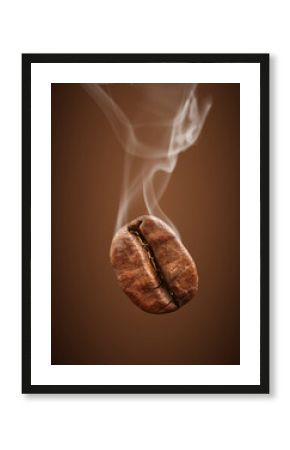 Closeup falling coffee bean with smoke on brown background