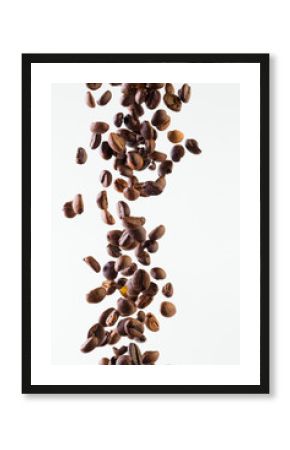 Falling grains of roasted coffee on a white background