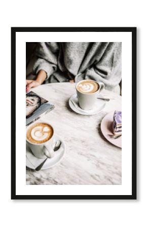 Female and man hands with cups of coffee on the background of a wooden table