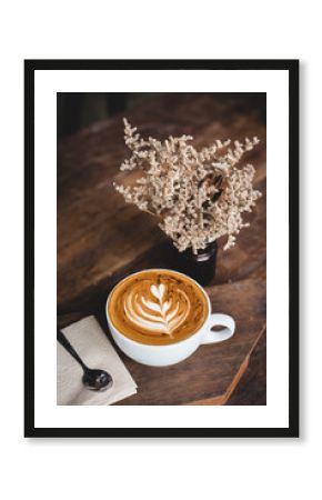 Cup of hot latte art coffee on wooden table